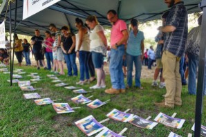 Diverse members from around the community and around the area view photos of the 49 people killed in the Orlando nightclub shooting following a memorial vigil Thursday at Bergfeld Park in Tyler. The names of the deceased and a brief biography of each was read during the emotional service. Andrew D. Brosig/Tyler Morning Telegraph